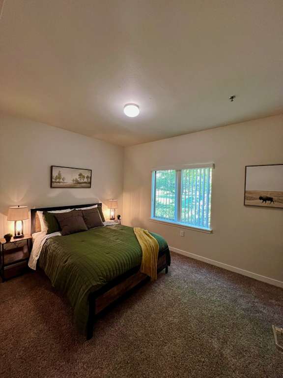 a large bedroom with a bed and a window  at Mullan Reserve Apartments, Montana