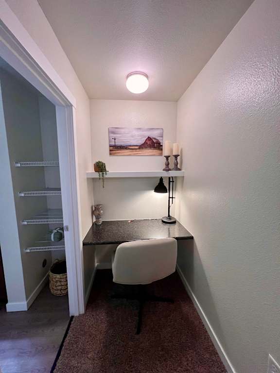 a small desk with a chair in a room with a closet  at Mullan Reserve Apartments, Montana