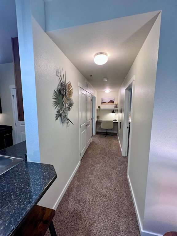 a hallway with white walls and a counter top and a long hallway with a kitchen  at Mullan Reserve Apartments, Missoula, Montana