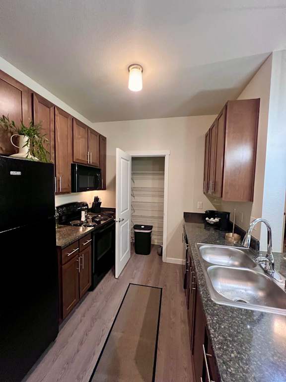a kitchen with wooden cabinets and granite counter tops  at Mullan Reserve Apartments, Missoula, Montana