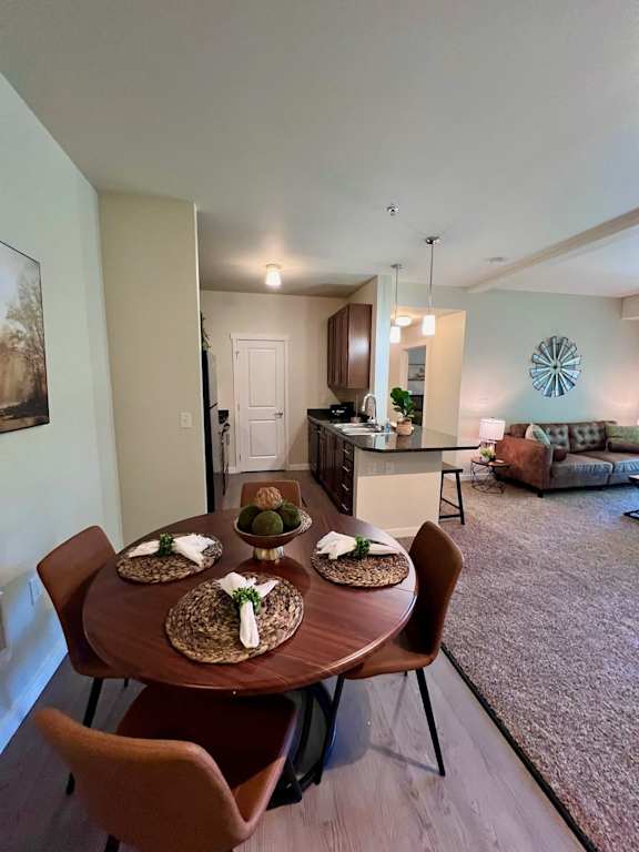 a dining room table in a living room with a kitchen  at Mullan Reserve Apartments, Missoula, MT, 59808