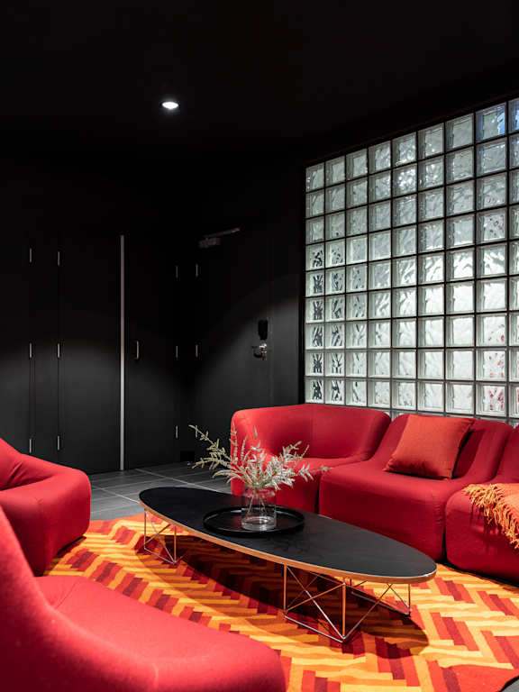 a living room with black walls and red couches and a table