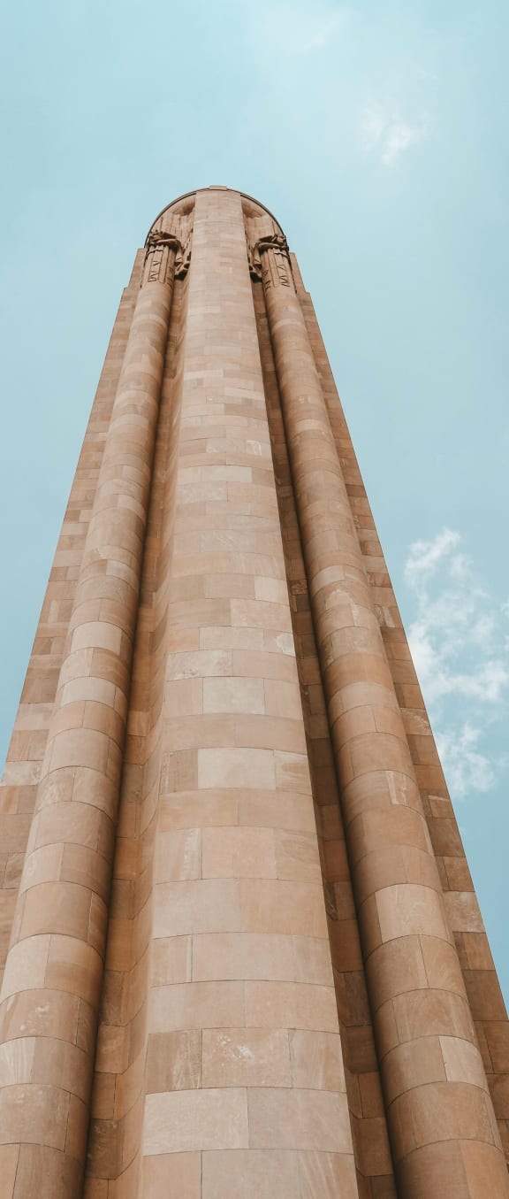 a tall building with columns in front of a blue sky