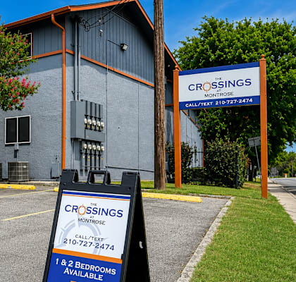 A sign in front of a building advertises Crossings, a company that offers 1 & 2 bedroom apartments.