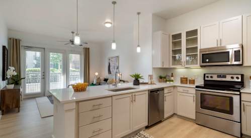 A modern kitchen with white cabinets and stainless steel appliances.