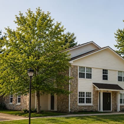 A two-story house with a white exterior and a black door.