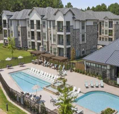 A large building with a pool in front of it.