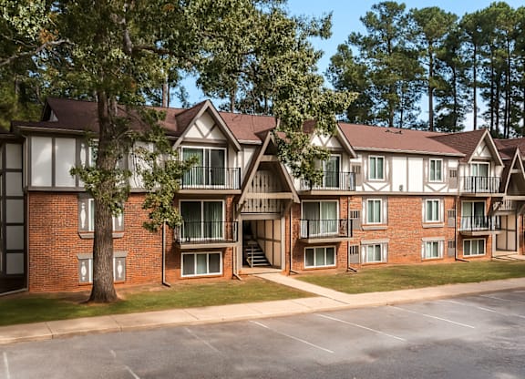 A large apartment complex with multiple buildings and a parking lot in front.