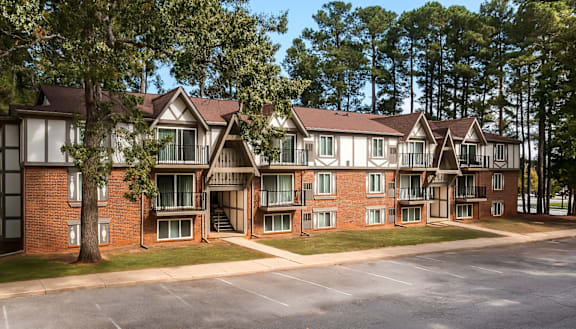 A large apartment complex with multiple buildings and a parking lot in front.