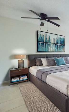 A bedroom with a large bed and a ceiling fan.
