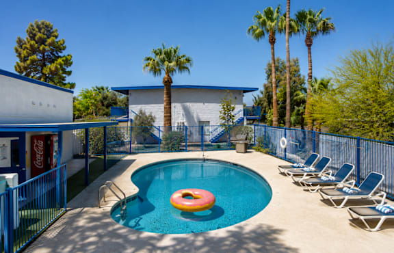 a resort style pool with chaise lounge chairs and grassy area