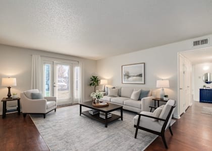 A living room with a grey sofa, a coffee table, and a painting on the wall.