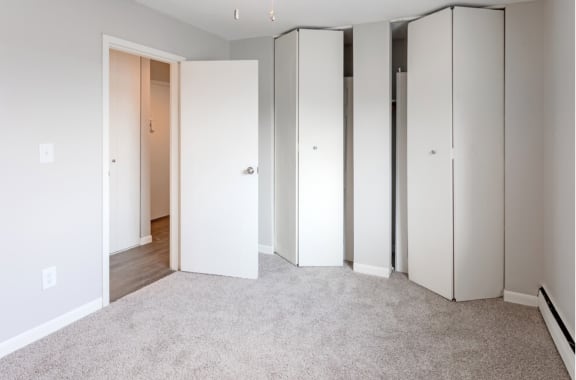 a bedroom with white walls and a carpeted floor