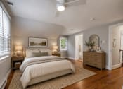 Thumbnail 3 of 4 - A bedroom with a large bed, a dresser, and a painting on the wall.