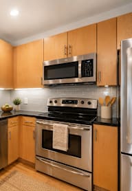 A modern kitchen with wooden cabinets and stainless steel appliances.