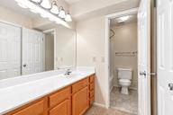 A white bathroom with a white toilet and a white sink.