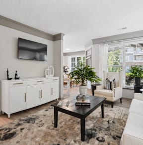 A living room with a black coffee table and a white sofa.