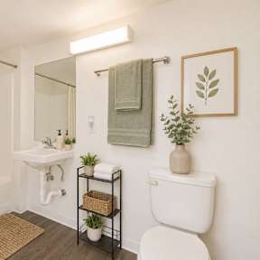 A bathroom with a white toilet, a white sink, a white bathtub, and a white shower curtain.