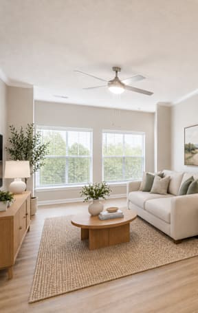 A modern living room with a white sofa, a coffee table, and a kitchen area in the background.