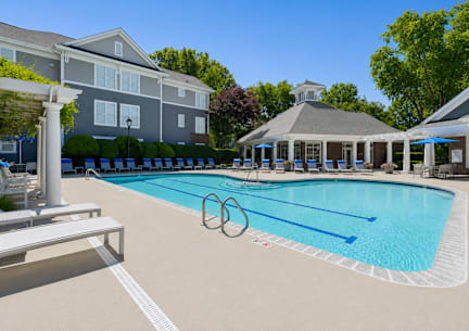 A large swimming pool in front of a residential building.