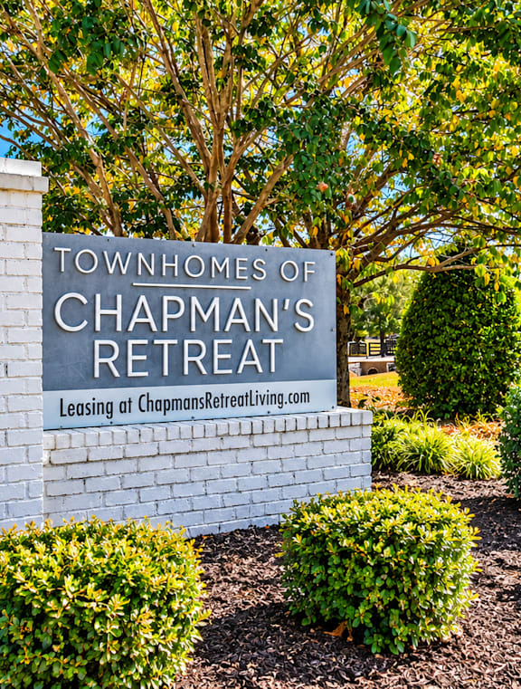 A sign for Chapman's Retreat stands in front of a tree.