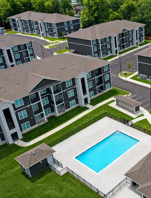 A swimming pool is surrounded by apartment buildings.