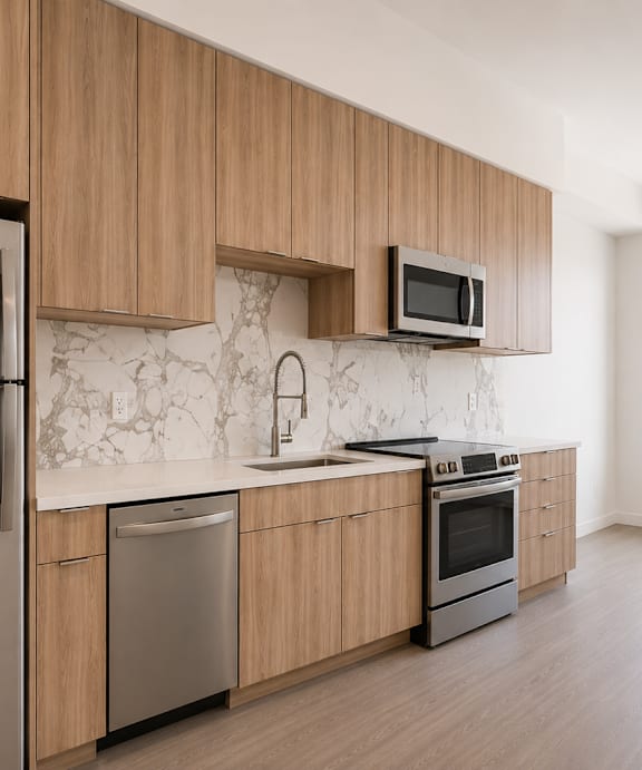 A kitchen with wooden cabinets and a window overlooking a cityscape.