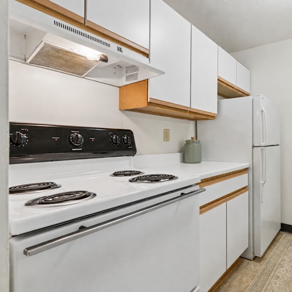 A kitchen with white appliances and wooden accents.