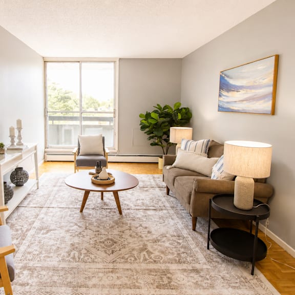 A living room with a grey couch, a round table, and a television.
