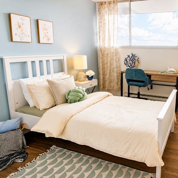 A bedroom with a large bed and a painting on the wall.