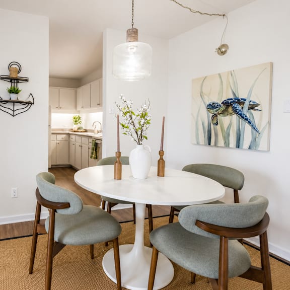 A living room with a grey couch, a round table, and a television.