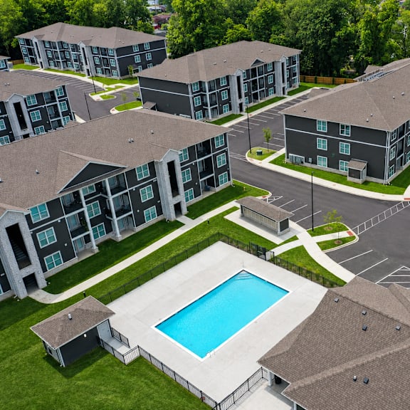 A swimming pool is surrounded by apartment buildings.