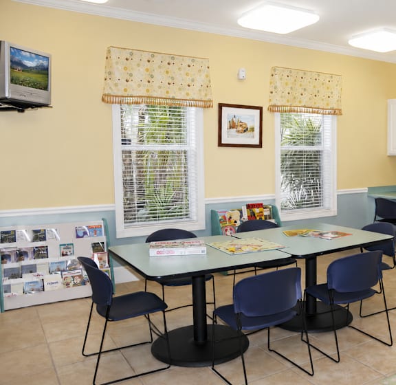 a room with a table and chairs and two windows