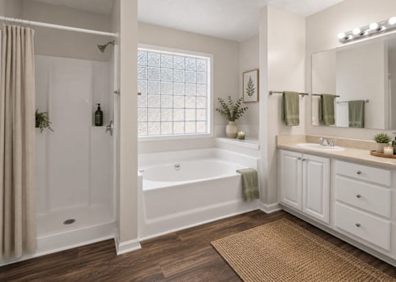 A white bathroom with a tub, sink, and mirror.