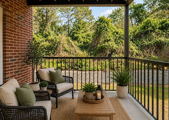A patio with a black railing and a wooden coffee table.