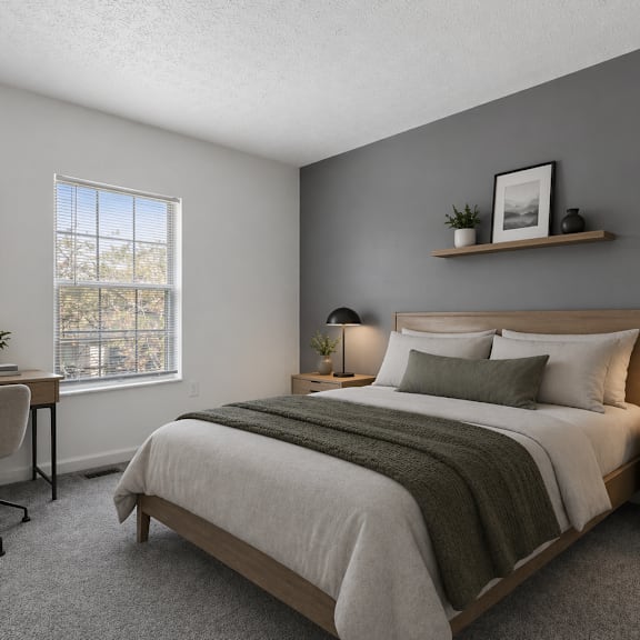 A bedroom with a large bed and two framed leaves on the wall.