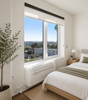 A modern living room with a dining table and a view of the city.