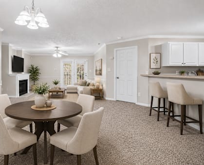 A living room with a fireplace and a dining table.