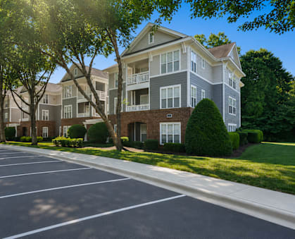 A sunny day at a residential area with apartment buildings and a parking lot.