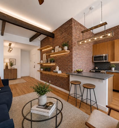 A modern kitchen with a blue sofa and wooden floors.