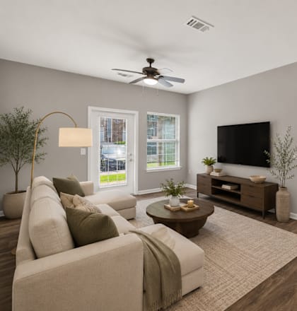 A living room with a beige couch, a wooden coffee table, and a flat screen TV.