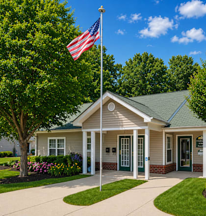 A small building with a flag on top and a sign in front that says "Future Homes".
