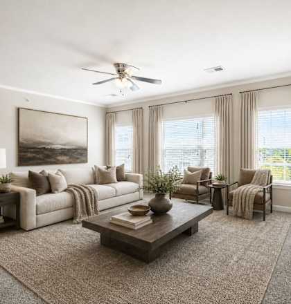 A well-lit living room with a large painting on the wall and a ceiling fan.