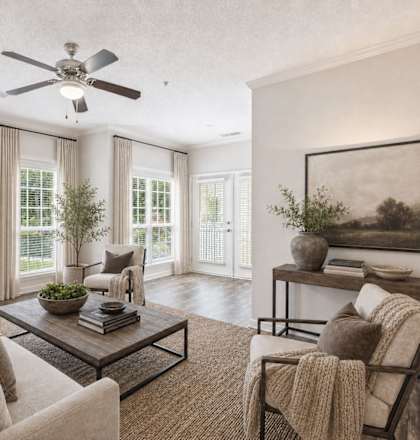 A living room with a couch, a coffee table, and a ceiling fan.