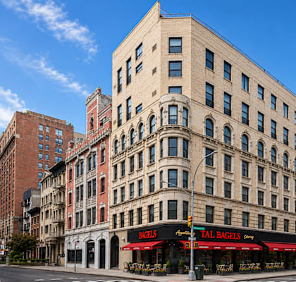 A tall building with a red awning that says "TAB BAGELS" on it.