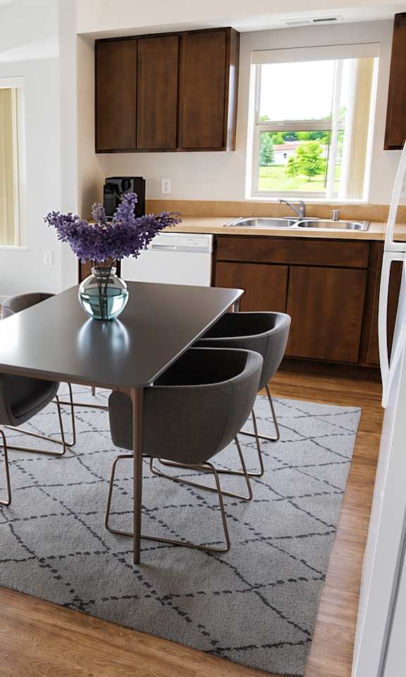 A modern dining room with a glass table and chairs.