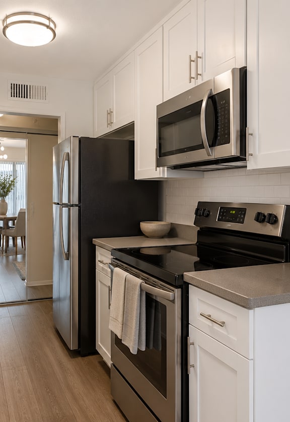 A kitchen with black appliances and white cabinets.