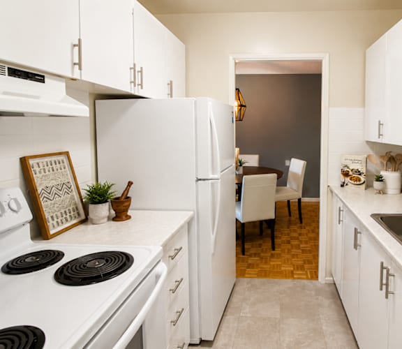 A kitchen with white appliances and cabinets.