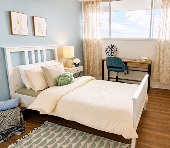 A bedroom with a bed, desk, and chair.