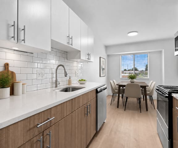 A modern kitchen with wooden cabinets and a dining table.